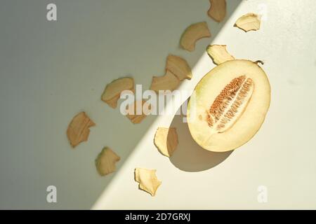Flat lay composition with fresh and dried melon slices on white table. Stock Photo