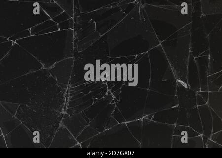 Black cracked glass texture background. Crack on the glass. Broken screen. Broken dark phone.  White cracks in glass Stock Photo