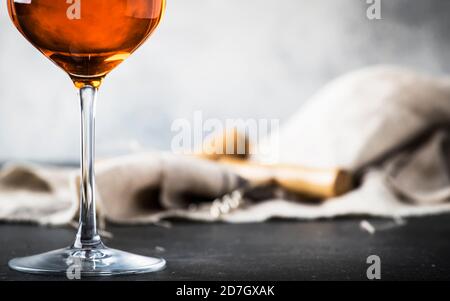 Orange wine in big wine glass, fashionable modern drink, gray counter background, copy space, selective focus Stock Photo