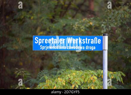 Spreetal, Germany. 19th Oct, 2020. A road sign 'Spreetaler Werkstraße' in German and Sorbian language is located at the roadside in front of deciduous trees. Credit: Soeren Stache/dpa-Zentralbild/ZB/dpa/Alamy Live News Stock Photo