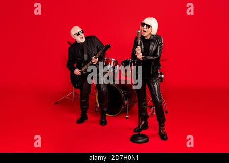 Again youth. Full body photo two people retired white gray hair pensioner wife husband rock fan garage studio stage woman sing song mic man play bass Stock Photo