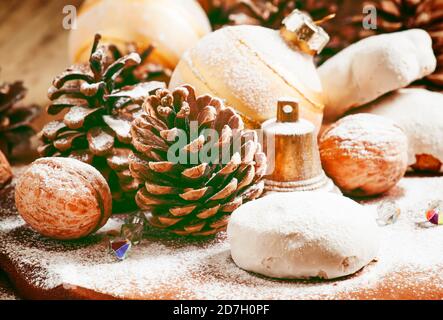 Gingerbread, fir cones, nuts, bell and ball on an old wooden table in rustic style, Christmas and New Year concept, toned image, selective focus Stock Photo
