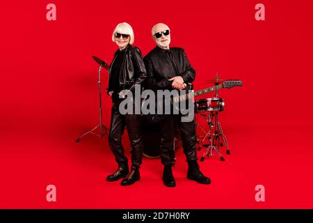 Full size photo popular artist old rock music group man bass guitarist woman drum player ready perform new composition practice stage wear leather Stock Photo