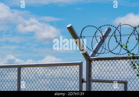 Prison security fence. Barbed wire security fence. Razor wire jail fence. Barrier border. Boundary security wall. Prison for arrest criminals. Stock Photo