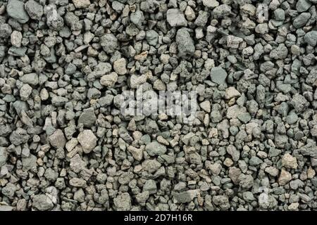 Gray small rocks ground texture. black small road stone background. gravel pebbles stone seamless texture. dark background of crushed granite gravel, Stock Photo