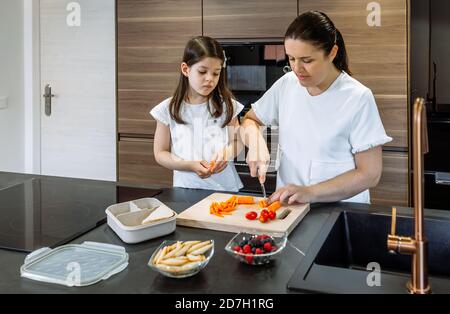 Mother preparing healthy snack for her daughter for school Stock Photo