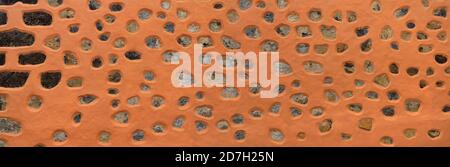 House wall made of lava stones and orange painted plaster Stock Photo