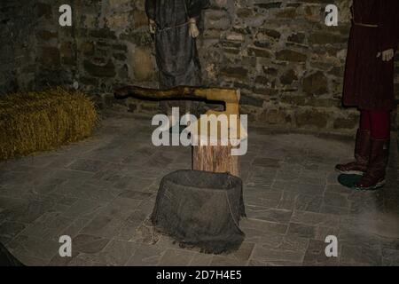 October 7, 2020: Khotyn, Ukraine - Axe of an medieval executor on the log in dungeon of ancient castle Stock Photo