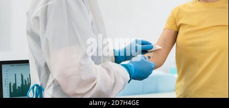 Doctor doing medical injection syringe vaccine to young patient in hospital for preventing and stop corona virus outbreak Stock Photo