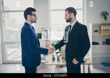 Profile side view of two nice attractive content trendy imposing men qualified finance expert employer hr shaking hands hiring talent human resources Stock Photo