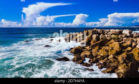 Drone photo of rocky pier or breakwater in the blue ocean. Costa Da Caparica, Setubal, Almada, Portugal Stock Photo