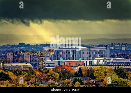 Glasgow, Scotland, UK. 23rd October, 2020: UK Weather: Grey and wet day saw Turbulent sky over the south of the city as sunbeams came through the storm clouds and the queen elizabeth hospital in govan saw autumnal colour. Credit: Gerard Ferry/Alamy Live News Stock Photo