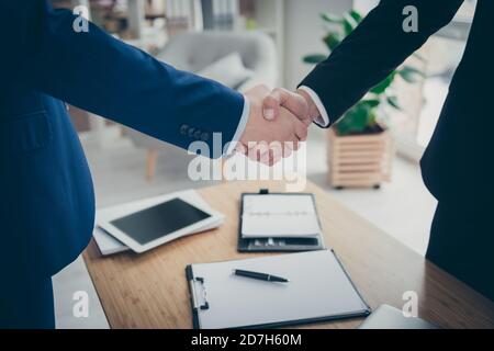 Cropped close-up view of two male hands shaking over table desk signed corporate contact assignment car life insurance service in light white interior Stock Photo