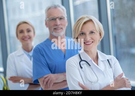 Group of smiling medical workers posing with arms folded Stock Photo