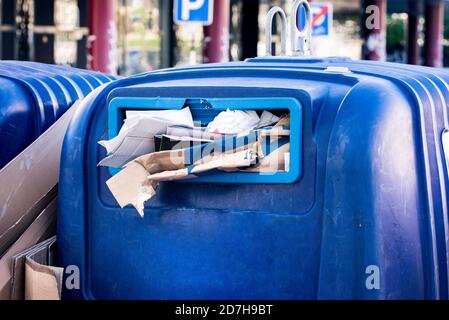 Full public paper and cardboard recycling trash container. Waste sorting.  Stock Photo