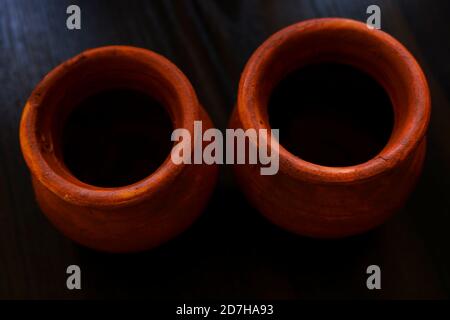 a top shot of handmade small clay pots isolated on wooden table Stock Photo