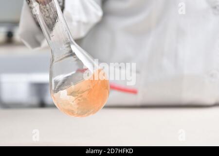 female laboratory assistant mixes liquid in a test tube in the laboratory Stock Photo