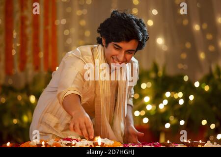 Young man lighting diwali diyas Stock Photo