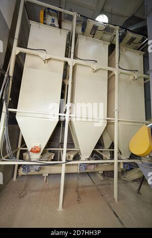 metal silos for storage of dry grain in a warehouse Stock Photo