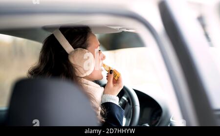 Happy young woman dressed in stylish clothes in a car. Stock Photo
