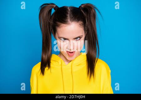 Photo of crazy funny carefree lady two tails making foolish faces eyes watch different ways childish person wear casual yellow hoodie pullover Stock Photo