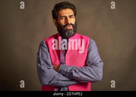 A young Indian man with a typical 'artist' and 'intellectual' look, in a slightly doubtful mood. Stock Photo