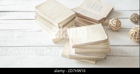A large stack of books with a white cover on a large light table. The concept of hobby and education. Stock Photo