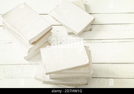 A large stack of books with a white cover on a large light table. The concept of hobby and education. Stock Photo