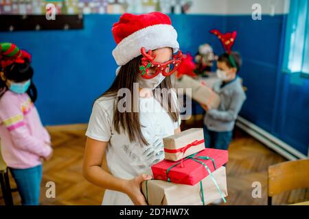 School children celebrating New Year in the classroom. They are wearing protective face mask Stock Photo
