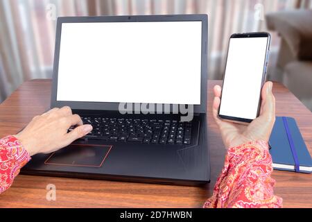Woman Using laptop and mobile phone at home as teleworking concept Stock Photo