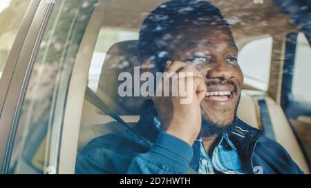 Handsome Young Entrepreneur Traveling on a Passenger Seat of a Car Makes a Phone Call, Talks with Clients or Relatives. Gets Good News. Camera Shot Stock Photo
