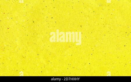 Yellow craft paper. Terrazzo texture. Bright lemon colour with small colored drops. Abstract holiday background. Stock Photo