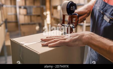 Warehouse Worker Checks and Sealing Cardboard Box Ready for Shipment. Stock Photo