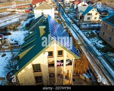 Aerial view of new modern two story house cottage with blue shiny solar photo voltaic panels system on the roof. Renewable ecological green energy pro Stock Photo