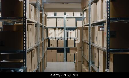 Shot Inside Warehouse Storeroom with Rows of Shelves Full Cardboard Boxes, Parcels, Packages Ready For Shipment. Stock Photo