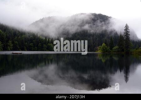 Fog and mist hanging over a lake in the temperate rainforest and Coast Mountains near Stewart and Hyder, Northern British Columbia, Canada. Stock Photo