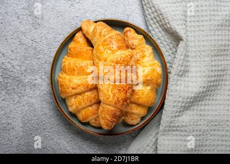 Fresh french croissants with chocolate on plate, napkin on gray granite background Continental morning breakfast Top view Flat lay Stock Photo