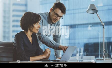 Beautiful Businesswoman Listens to Professional Advisor in Her Office, They Discuss Data Show on a Laptop. Smart Young Businesspeople Working in Stock Photo