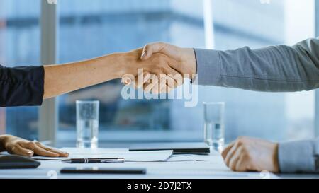 Close-up of the Businesswoman and Businessman Closing the Deal and Shaking Hands in Agreement. Close-up on Hands two Businesspeople Conclude a Stock Photo