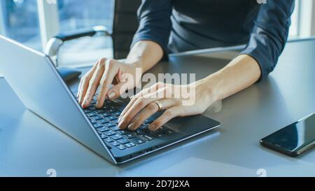 Close-up On the Hands of a Businesswoman Typing on a Laptop Keyboard. Female Using Laptop in the Office. Stock Photo