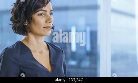 Portrait of the Successful Businesswoman Executive Standing in Her Office and Looking Outside. Stock Photo