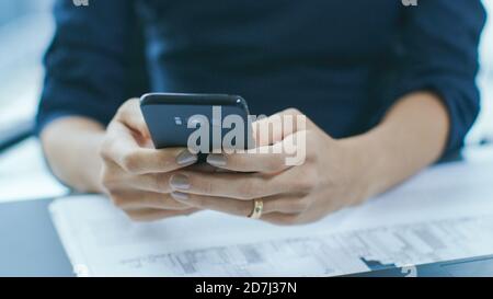 Shot of the Businesswoman Working at Her Office Desk Using Her Last Model Smartphone. Focus on a Phone. Stock Photo