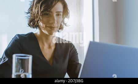 Portrait of the Focused Female CEO Working on a Laptop. Happy Successful Businesswoman Doing Her Important Business Job Beautifully. Stock Photo