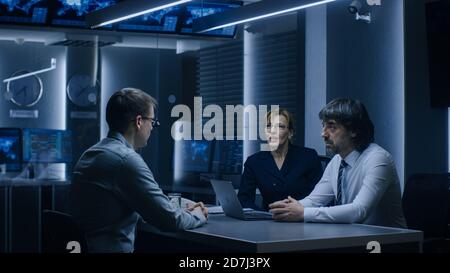 On a Job Interview Two Senior Managers Ask Young Candidate Questions. Secret Service Recruiting Talented Young Man. Serious People Working in Stock Photo