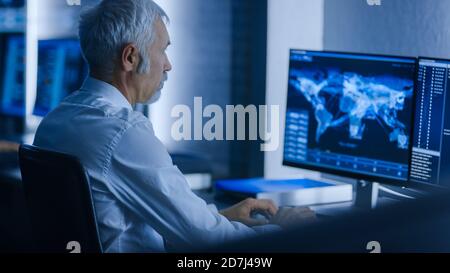 Team of Technical Specialists Working On Personal Computers at Their Workstations in the System Control Room.  Stock Photo