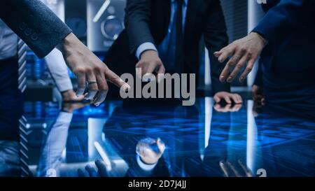 Diverse Team of Government Intelligence Agents Standing Around Digital Touch Screen Table and Satellite Tracking Suspect, Pointing at Display. Big Stock Photo