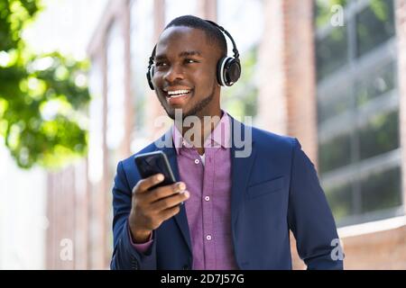 African American Man Listening Music On Wireless Headphones Outside Stock Photo