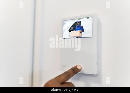 African Man Using Video Intercom Entrance Safety System Stock Photo