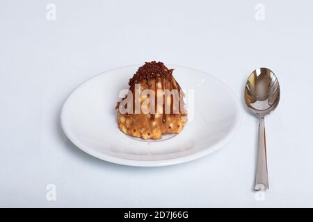 Traditional Russian cake or Anthill pastry on a white plate with a spoon on a white background. Unhealthy food concept Stock Photo