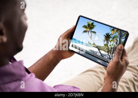 Young African Man Watching Video On Tablet Stock Photo
